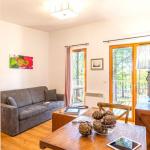 Slide Salon intérieur d’un cottage au Valjoly avec canapé, coin repas en bois, télévision et baie vitrée ouvrant sur la terrasse