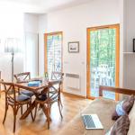 Slide Espace salon d’un cottage au Valjoly avec canapé, coin repas en bois, télévision et accès direct à la terrasse extérieure