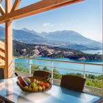 Slide alcon avec table et panier de fruits à la résidence L’Écrin du Lac à Chorges, offrant une vue imprenable sur le lac de Serre-Ponçon et les montagnes
