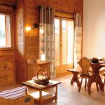 Slide Salon chaleureux avec coin repas et grandes fenêtres donnant sur les montagnes aux Fermes de Samoëns.