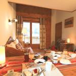 Slide Séjour cosy aux Fermes de Samoëns avec table dressée pour le petit-déjeuner et canapé en bois.