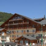 Slide L'Ours Blanc residence in Les Deux Alpes with wooden façade under beautiful sunshine