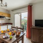 Slide Kitchen and dining room with table set in the Domaine des Cazelles residence