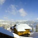 Slide view of the Le Hameau de Beaufortain residence over snow-capped mountains and beautiful sunshine