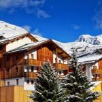 Slide Résidence Les Etoiles d'Orion composée de batiments en bois et recouvert de neige