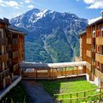 Slide View of the Les Etoiles d'Orion residence in the mountains surrounding it in summer