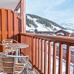 Slide Balcon avec petite table et chaises vue sur les montagnes enneigées à la résidence Les Chalets d’Emeraude