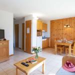 Slide Living room with open kitchen and lounge area with TV at the Résidence L’Orée des Pistes