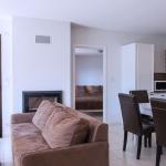 Slide Overview of the living room with sofa and dining table in the apartments at the L’Écrin du Lac estate in Chorges
