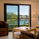 Slide Living room with sofa and flat-screen TV with lake view at L’Écrin du Lac in Chorges