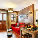 Slide Overview of the living room with lounge area, dining table, and a glimpse of the bedroom at Le Grand Lodge in Châtel