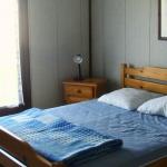 Slide Double bedroom with bedside table in a house at the Résidence Les Tamaris & Les Portes du Soleil