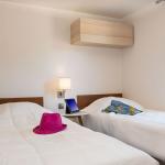 Slide Chambre avec deux lits simples et meuble de rangement en hauteur dans le cottage vip au village vacances Les Mûriers