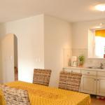 Slide Dining area with table and open kitchen in a house at Le Clos des Oliviers residence