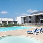 Slide Outdoor swimming pool with paddling pool and sun loungers at the Fleur de Sel Residence