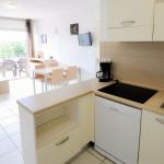 Slide Fully equipped kitchen opening onto the living room of an apartment in the Château de Jouarres residence in Azille