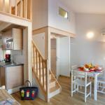 Slide Séjour ouvert sur une cuisine équipée avec TV dans les maisonnettes des Sabees Vignier à Oléron