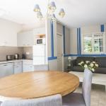 Slide Overview of a living room with open kitchen, lounge and dining table in an apartment for 6 people in the Iduki Hills