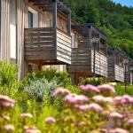 Slide Wooden exterior façades of the accommodations at Résidence Le Clos du Rocher in Dordogne