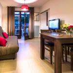 Slide Living area with dining space and lounge in an apartment at Résidence Le Clos du Rocher in Dordogne