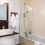 Slide Bathroom with bathtub and sink in an apartment at Résidence Le Clos du Rocher in Dordogne