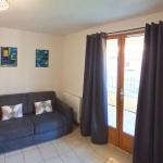 Slide Bright living room with pull-out sofa and television in the apartments of the Le Hameau des Sources residence in Montbrun-les-Bains