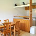 Slide Fully equipped kitchen area with dining space in one of the accommodations at Le Hameau des Sources in Montbrun-les-Bains