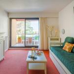 Slide Living room with sofa and television in an apartment at Résidence du Golf