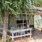 Slide View of a covered terrace with garden furniture and a BBQ in the Premium Bungalows at Camping del Mar 4* in Malgrat de Mar