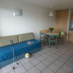 Slide Living area with sofa bed and fully equipped open kitchen in a studio at the Eugénie residence in Biarritz