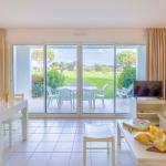 Slide Spacious, fully equipped living room with television and sofa bed opening onto a private outdoor area overlooking the residence’s gardens at the L’Estran residence in Les Sables-d’Olonne