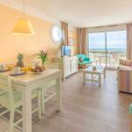 Slide Living area with television and sofa bed opening onto a private balcony with sea view at the L’Estran residence in Les Sables-d’Olonne