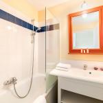 Slide Bathroom fitted with a bathtub, single washbasin, and mirror in one of the accommodations at the L’Estran residence in Les Sables-d’Olonne