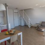 Slide Vue d’ensemble d’un séjour d’un appartement en duplex de la résidence Sokoburu avec coin repas, salon et cuisine ouverte