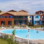 Slide Piscine centrale chauffée entourée d'ilots de maison au style cabane de pêcheur à la résidence Les Rives Marines au Teich