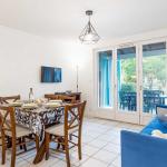 Slide Living area of a different layout, furnished with table, chairs and television, opening onto a terrace in one of the apartments at the Les Rives Marines residence in Le Teich