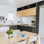 Slide Open-plan kitchen leading to the dining area in a Premium cottage at Les Places Dorées***** campsite