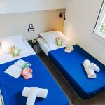 Slide Bedroom with two single beds in the Premium 4-person cottage at Les Places Dorées***** campsite