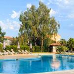 Slide Unheated outdoor swimming pool with sun loungers, surrounded by lush green gardens at the Sognu di Mare residence in Linguizzetta