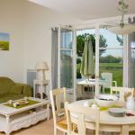 Slide Living room of a Fontenelles house with lounge and dining areas, offering views of and direct access to the golf course