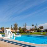 Slide Unheated outdoor swimming pool of the Pedras del Rei residence with green space and sun loungers in the background
