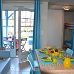 Slide Espace à vivre avec table à manger donnant sur une porte vitrée et sur la terrasse privative au sein d’un logement de la résidence La Grenadine