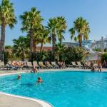 Slide Outdoor swimming pool with sun loungers, slides and palm trees at Résidence Antinéa