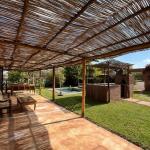 Slide Large shaded terrace with outdoor furniture, opening onto the enclosed garden at Villa Dar Wellness