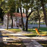 Slide Outdoor area of the Sveta Ana Lodges cottages set in a park, with sun loungers and the option to rent a barbecue