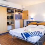 Slide Interior of a studio apartment in the Neptune residence with kitchenette and sofa bed.