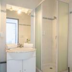 Slide Shower room of a studio apartment in the Neptune residence with washbasin and toilet.