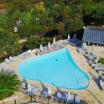 Slide Heart-shaped infinity pool with sun loungers and parasols overlooking the sea at Camping Lacasa in Calcatoggio