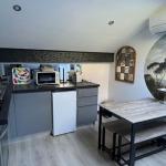 Slide Pièce à vivre avec coin cuisine équipé climatisation et table pour manger dans l'appartement Némo
