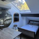 Slide Coin nuit dans le séjour avec un lit, TV dans l'appartement Némo à Marseille